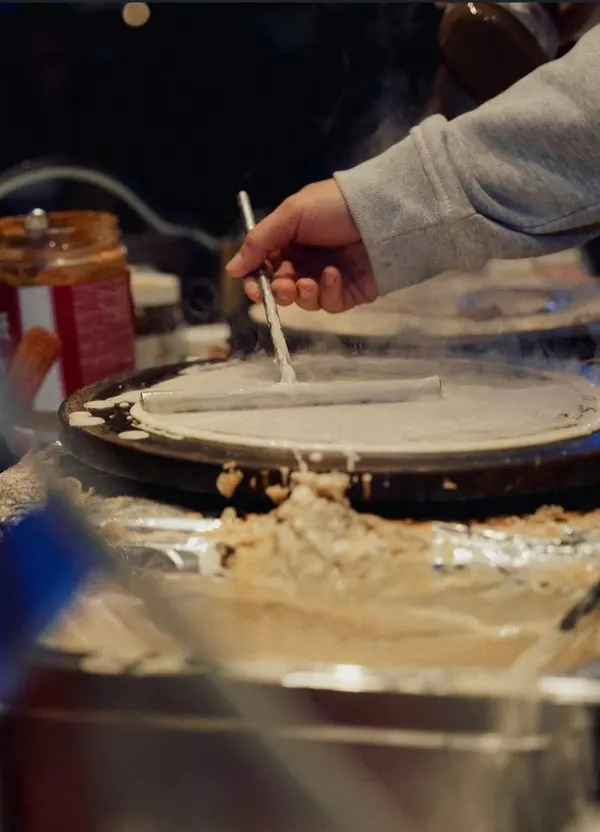 Crêpe-Teig wird live auf der heißen Platte verstrichen